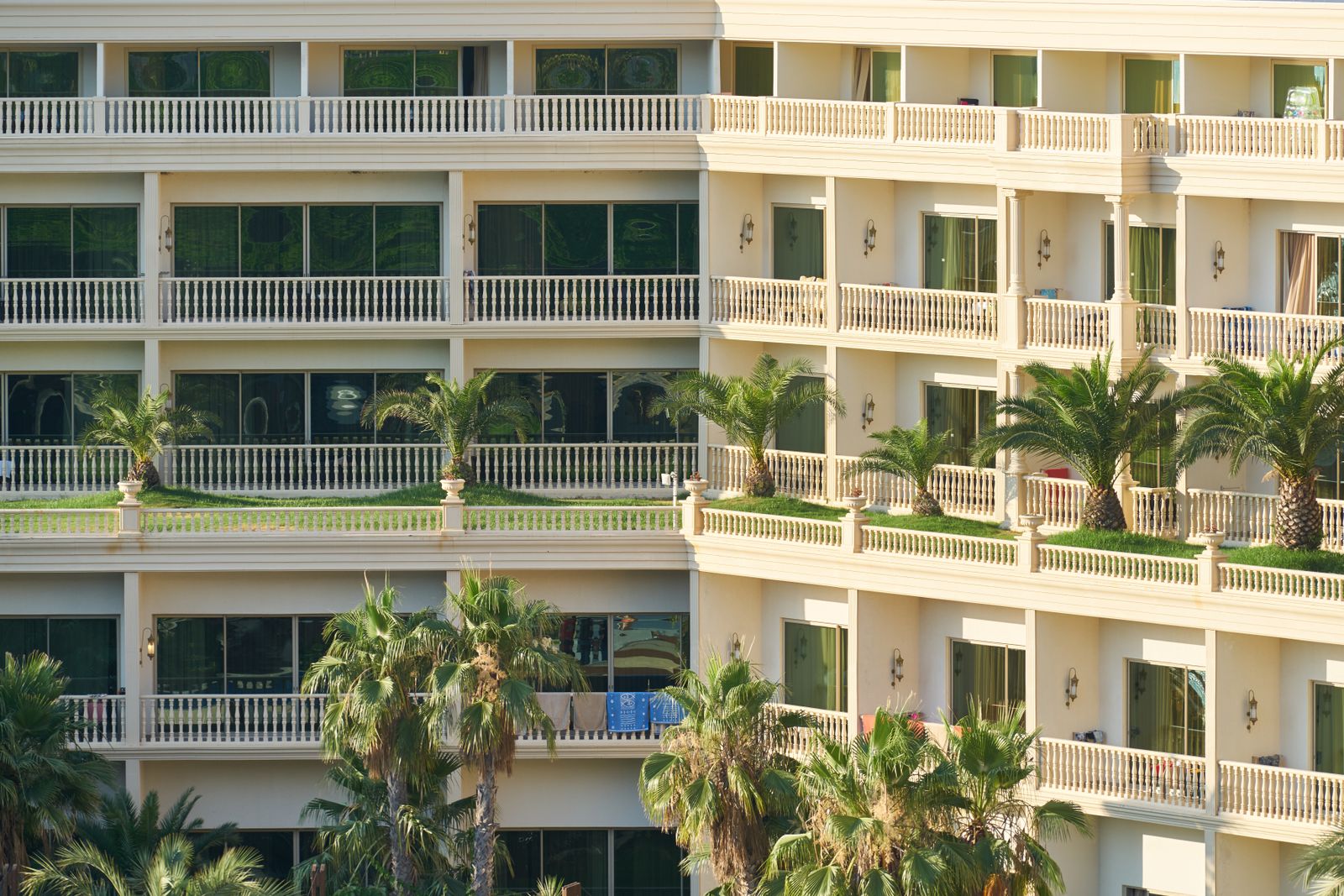 Apartment building with balconies and palm trees