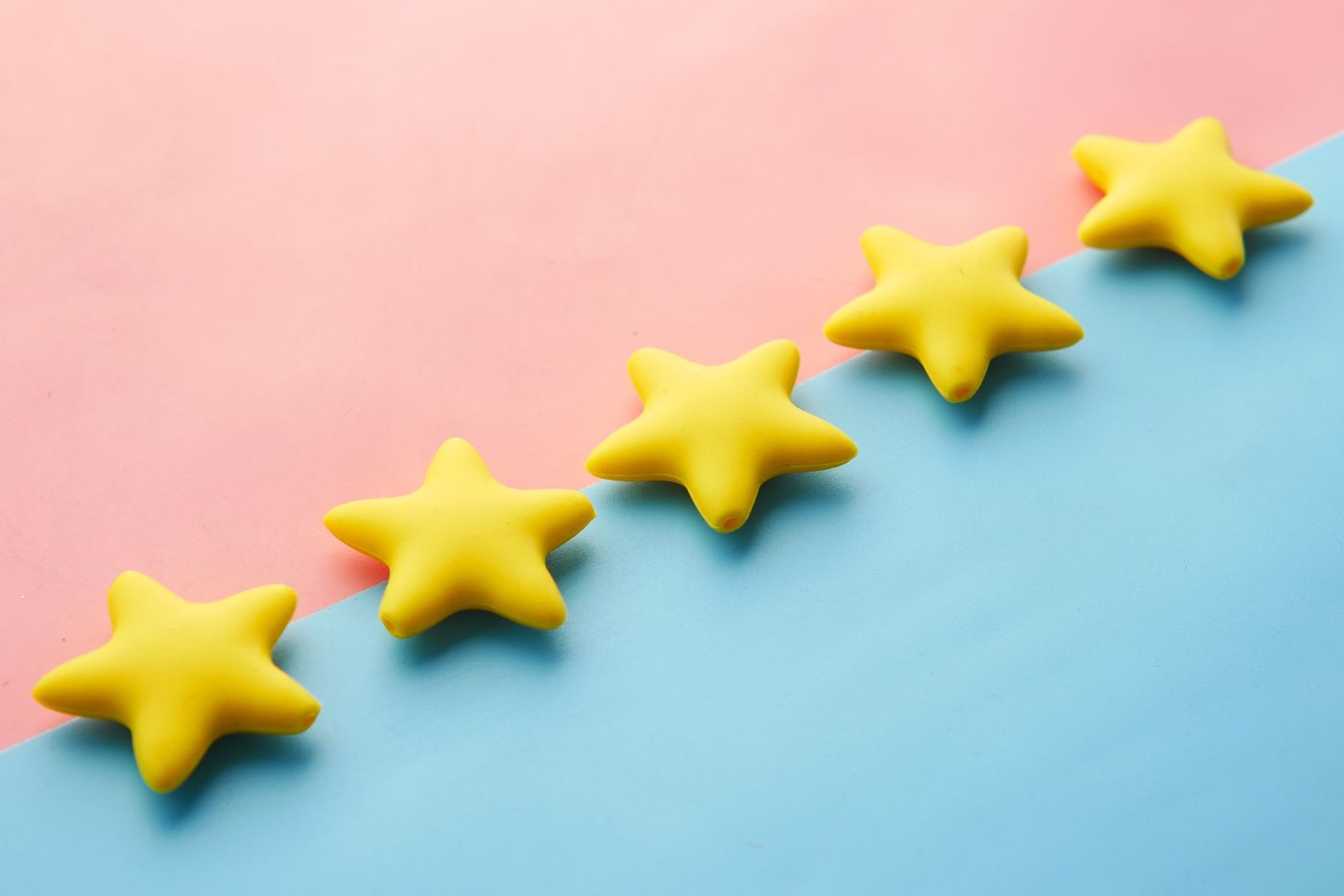 Five yellow stars arranged on a blue and pink background