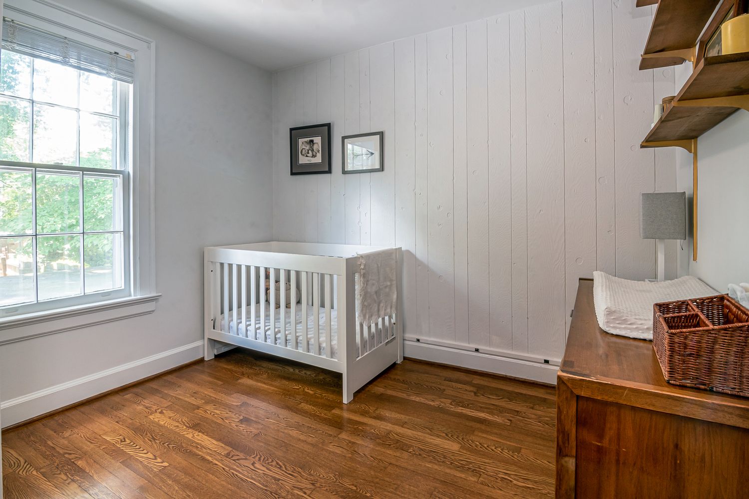 White wooden crib in a bright room beside a window