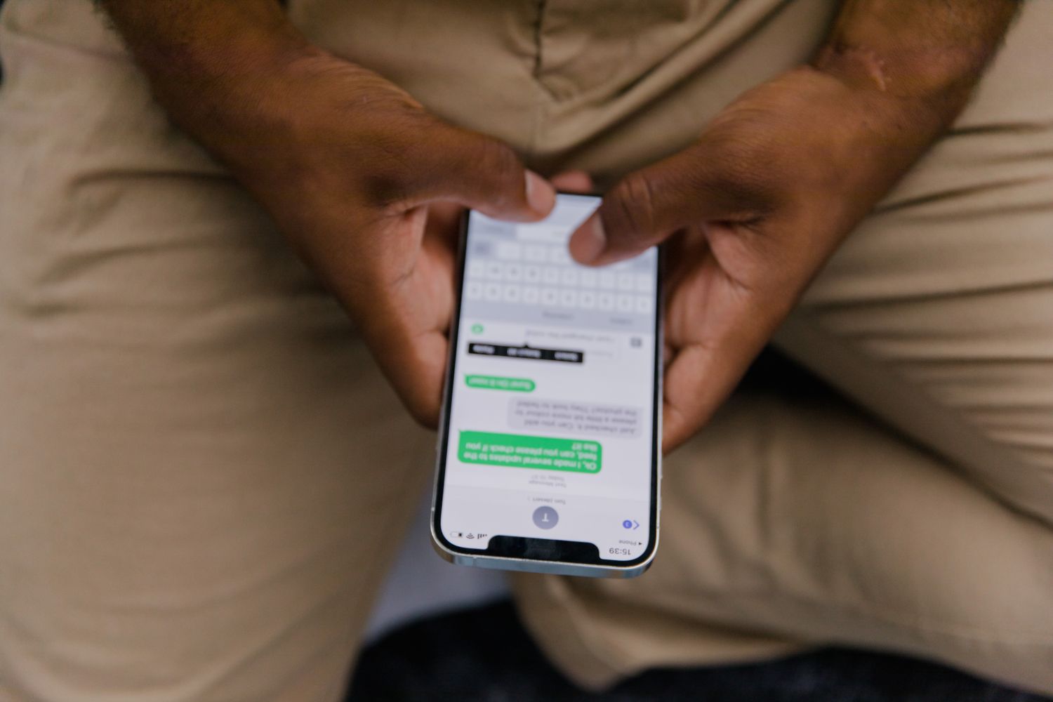 Close-up of hands replying to a guest message on a smartphone