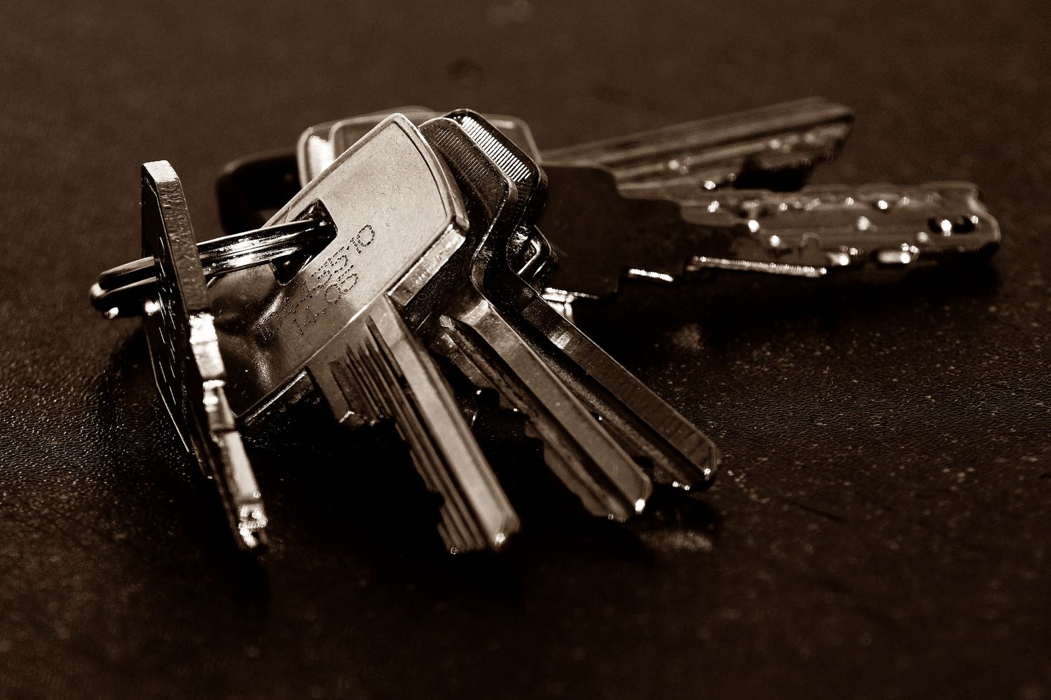 Pile of assorted metal keys on a dark surface
